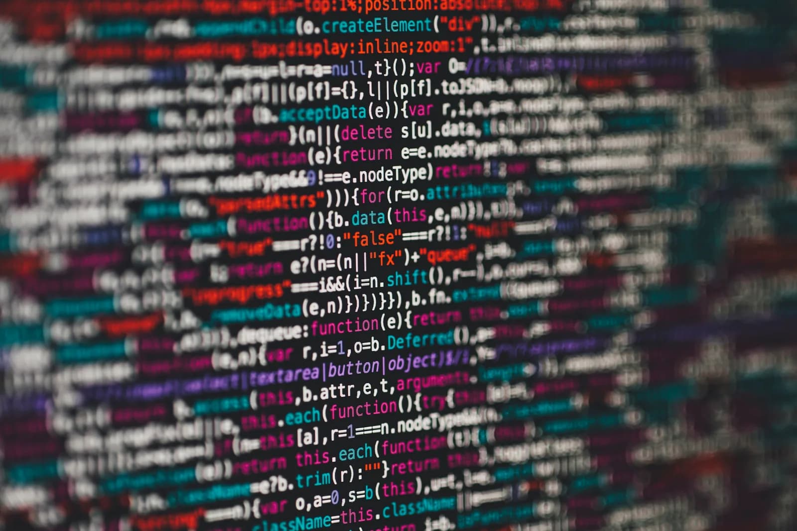 Monitor showing colourful web application source code, including PHP, in a code editor