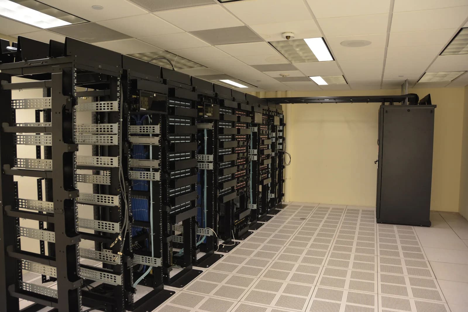 Rows of server racks with blinking status lights inside a data centre aisle