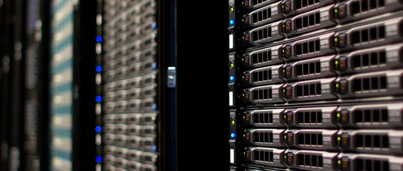Wide view of rack-mounted servers with front panels and network cables in a server room
