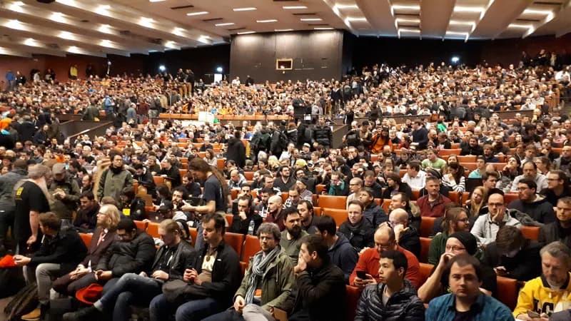A packed lecture theatre of attendees at the FOSDEM 2018 closing session, a free and open-source software conference