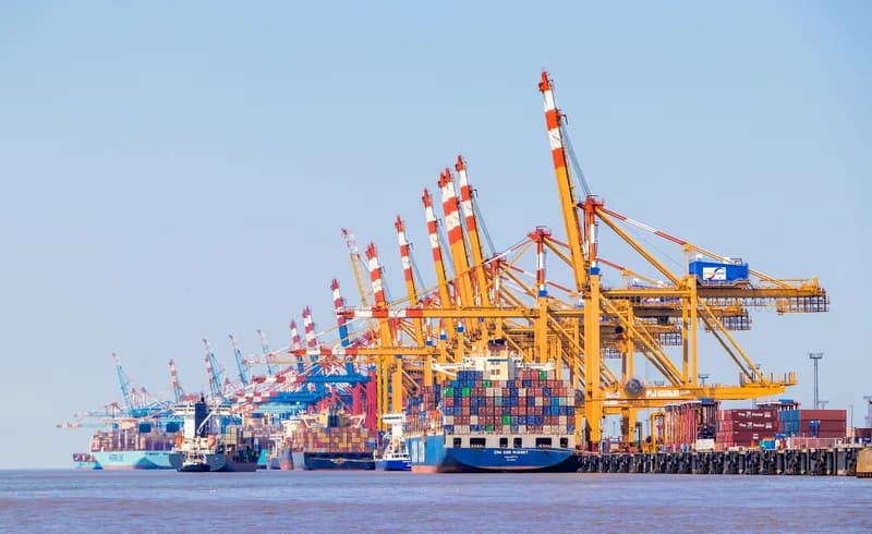 Stacked shipping containers and gantry cranes at the container terminal in Bremerhaven, Germany