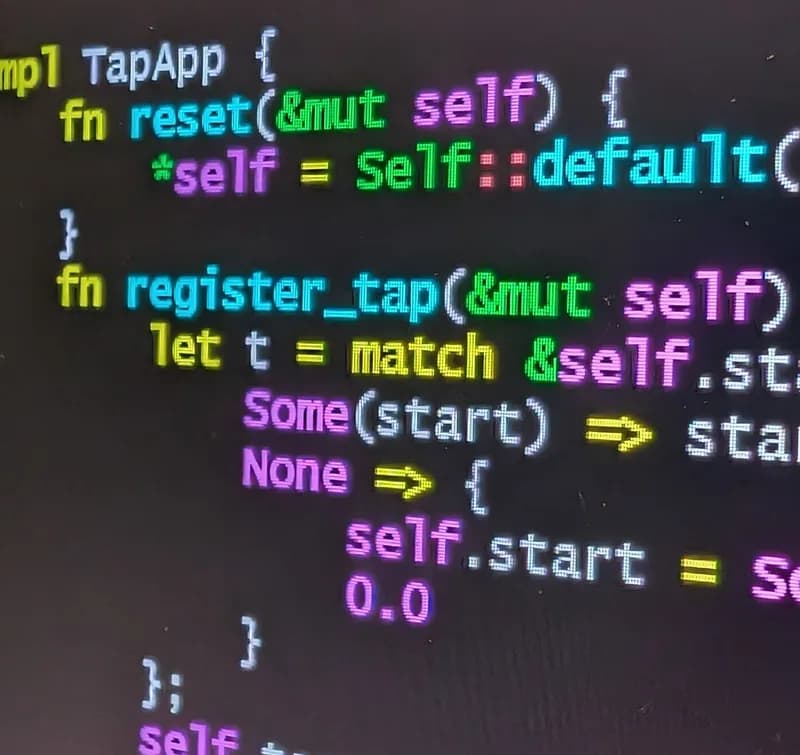 Close-up of colour-highlighted Rust source code on a laptop screen, showing a struct implementation with match arms