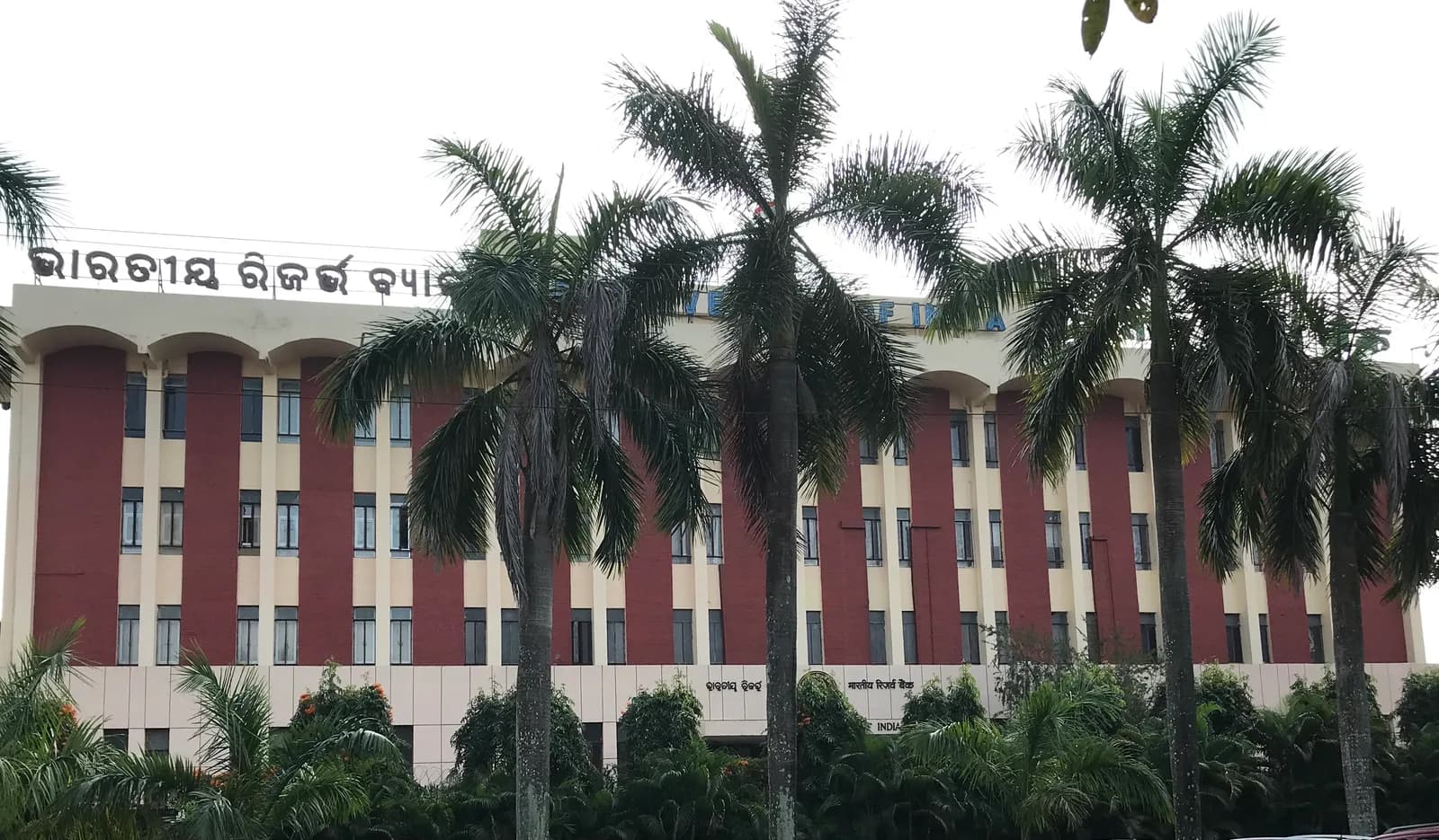 Reserve Bank of India regional office in Bhubaneswar, a red and cream building behind palm trees
