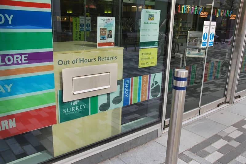 Out of Hours Returns book drop slot set into the glass front of Woking Library