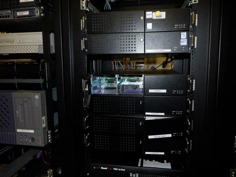 Black server rack holding stacked rack-mounted servers and network equipment with status lights