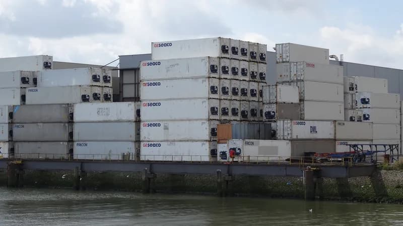 Stacks of white refrigerated shipping containers on a quay beside the water at the Port of Rotterdam