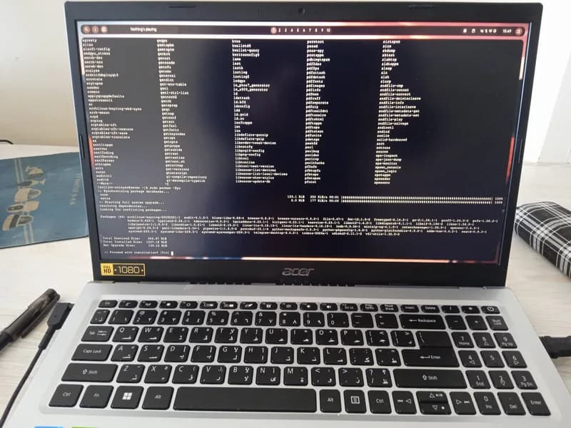Laptop on a desk with a terminal window full of command output filling the screen