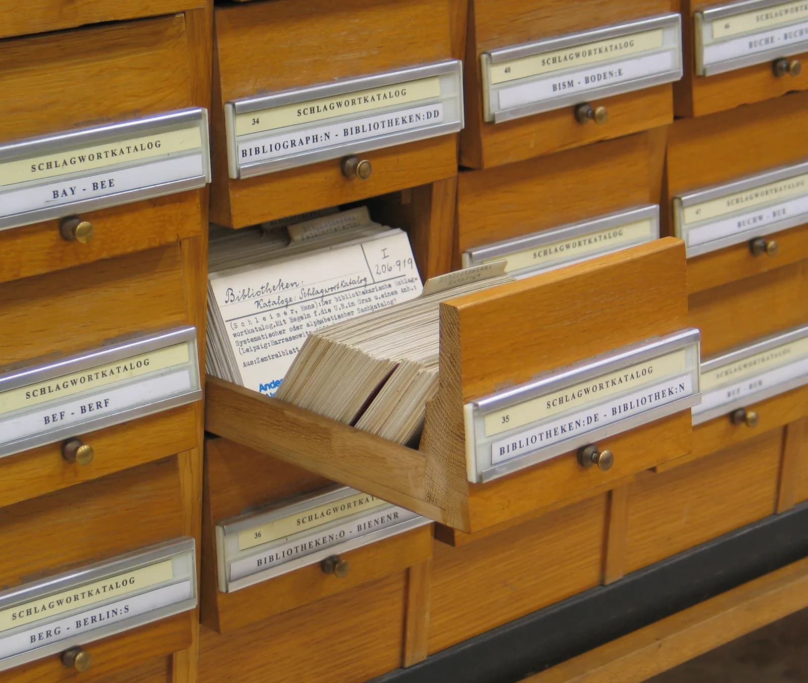 Wooden drawers of the subject-heading catalogue at the University Library of Graz, one drawer open showing index cards filed under keywords