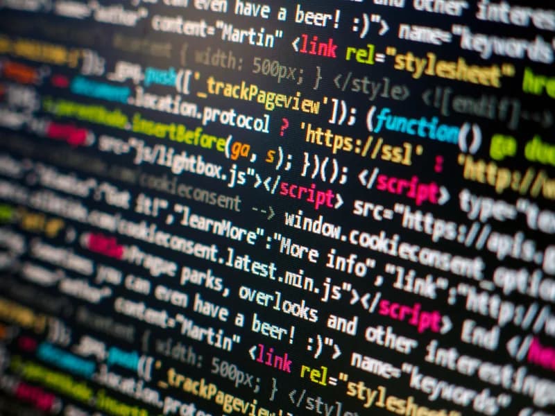 Close-up of colourful JavaScript and HTML source code on a monitor.