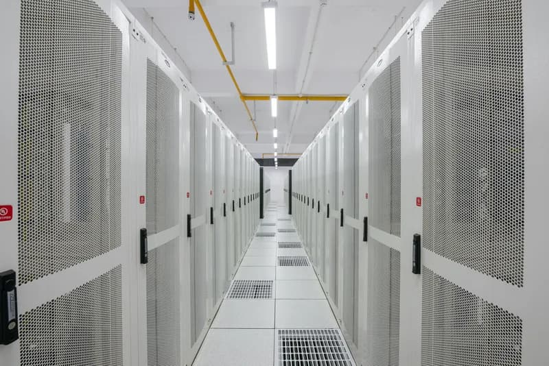 Long aisle of white server racks in a data centre.
