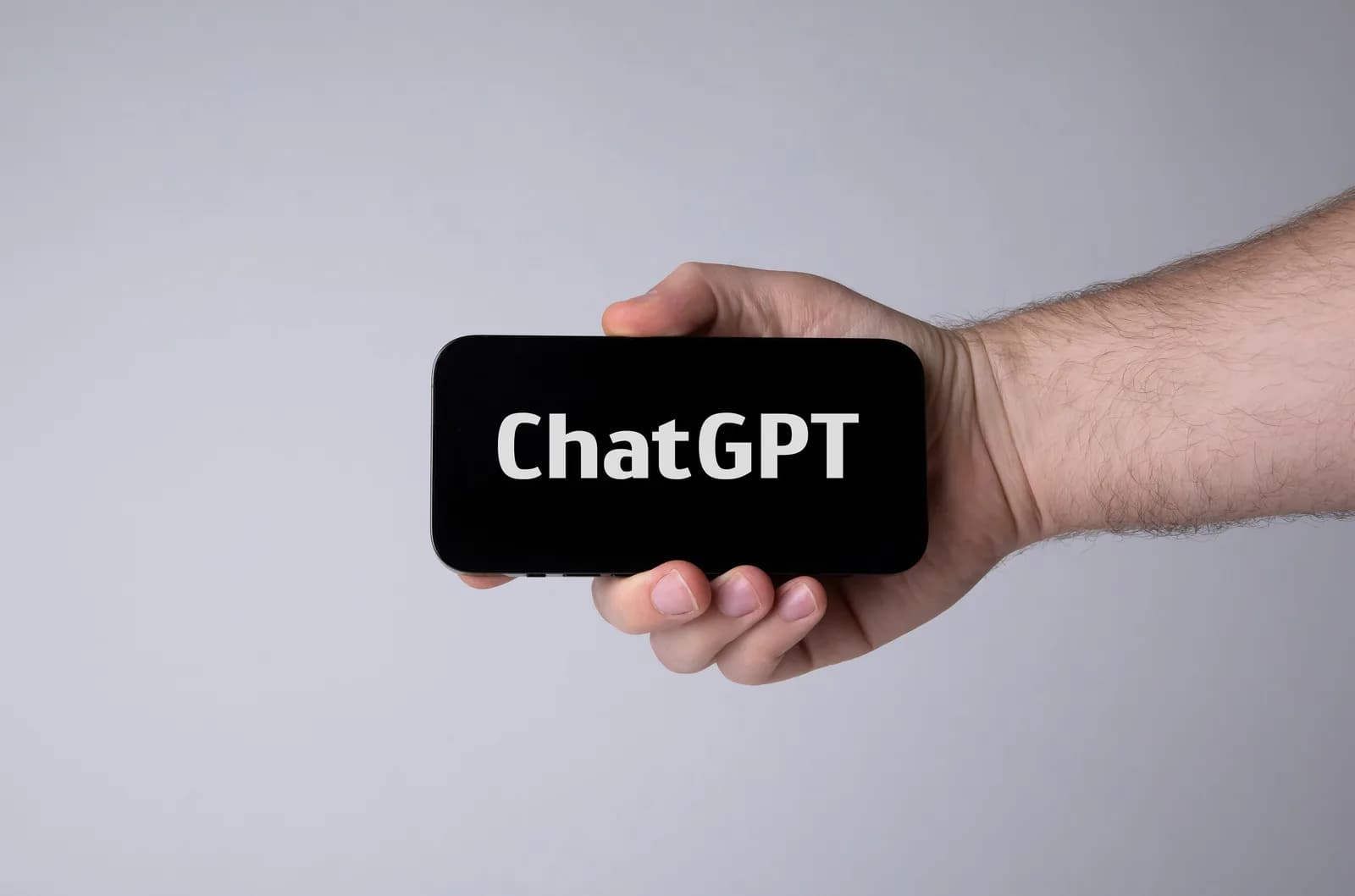 Hand holding a smartphone showing the ChatGPT name.